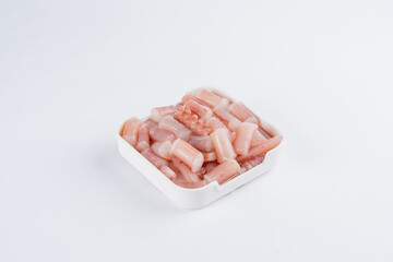 Close up view of diced seafood in a small white square container against a white background.