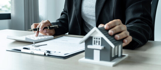 Sale Estate agent giving house model and key to new client after signing agreement contract with...