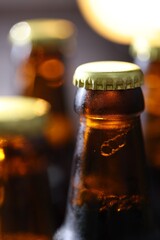 Bottle of tasty beer on blurred grey background, macro view