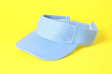One light blue visor cap on yellow background, closeup. Mockup for design