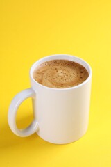 Aromatic coffee in cup on yellow background, closeup. Mockup for design
