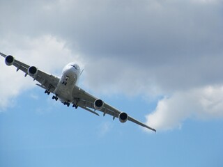 Powerful airliner ascending into the bright blue sky with fluffy clouds for travel and tourism ads