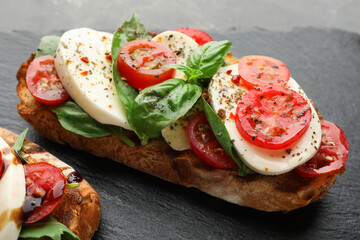 Delicious sandwiches with mozzarella cheese, tomatoes and basil on table, closeup