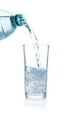 Pouring refreshing soda water from bottle into glass on white background