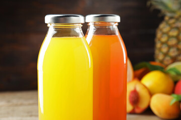 Tasty juices in glass bottles on blurred background, closeup