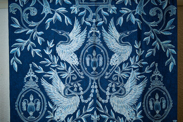 Elegant indigo batik fabric with white crane and floral pattern, showcasing traditional Indonesian...