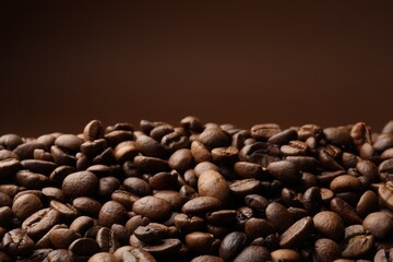 Pile of roasted coffee beans on brown background, closeup