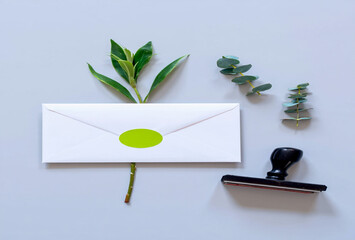 White envelope with green leaf and stamp on a light background