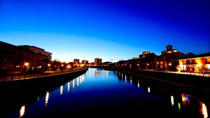 Obraz premium Tranquil Urban Canal at Dusk with Vibrant City Reflections 