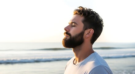 A man with a beard meditates peacefully on the beach at sunset, embracing tranquility and natures beauty