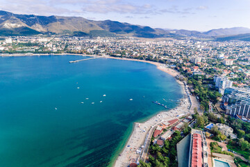 Panorama of Gelendzhik resort from a drone. The city of Gelendzhik on the shore of Gelendzhik Bay at the foot of the mountains. Numerous white sails in the emerald water of the Black Sea