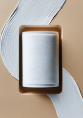 Top view of white cylinder inside kraft tray with curved paint strokes for clean minimal design