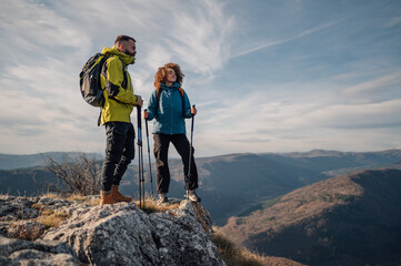 Hikers standing on mountain top enjoying scenic view