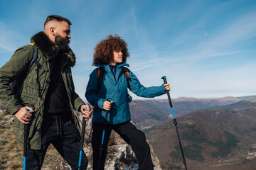 Hikers using trekking poles enjoying scenic mountain view