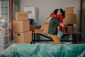 Happy couple hugging in new apartment, celebrating moving day