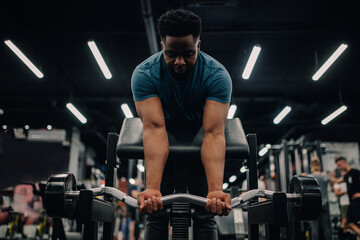 Determined bodybuilder lifting weights in modern gym