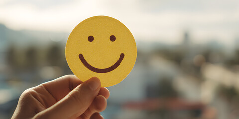 Hand holding paper cut smile face, positive thinking mental health assessment world mental health day cncept, generative ai