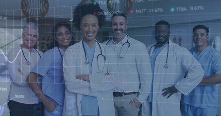 Analyzing charts medical team wearing stethoscopes reviewing stock tickers in hospital corridor
