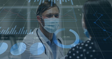 Consulting physician in scrubs, mask and stethoscope, seeing patient in clinic with digital charts