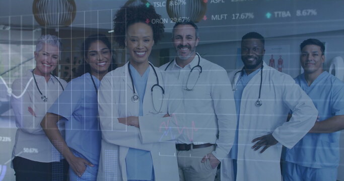 Analyzing charts medical team wearing stethoscopes reviewing stock tickers in hospital corridor - Powered by Adobe