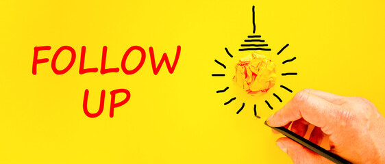 Follow up symbol. Concept word Follow up on beautiful yellow paper. Businessman's hand. Light bulb...