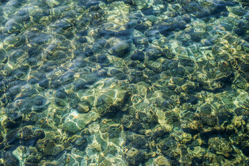The water is clear and the rocks are scattered throughout