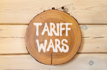 Trade tariff wars symbol. Concept word Tariff wars on beautiful wooden circle on wooden wall....