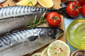 Fresh raw mackerels and spices on light blue wooden table, flat lay. Seafood delicacies