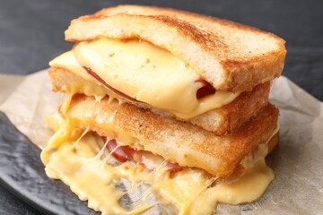 Tasty sandwiches with melted cheese and ham on table, closeup