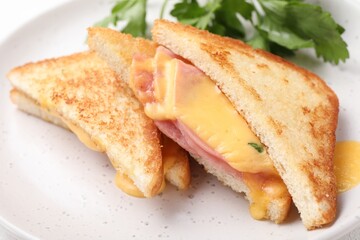 Delicious sandwiches with melted cheese and ham on white table, closeup