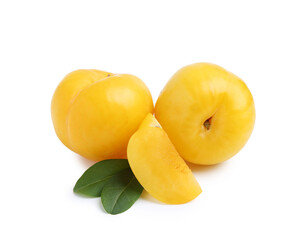 Whole and cut yellow cherry plums with leaves isolated on white