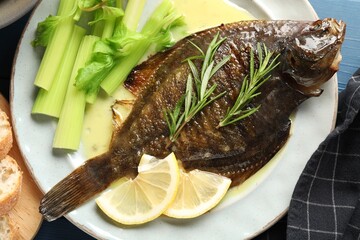 Tasty roasted flounder fish with celery served on blue table, closeup. Homemade seafood dish