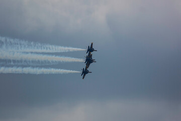 4 US Navy F/A-18  Super Hornet fighter attack jets flying in formation with streaking white trails