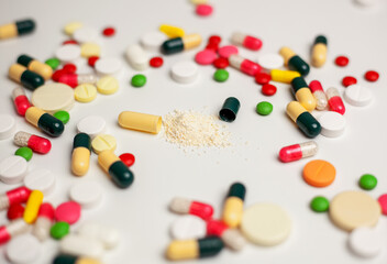 Colorful tablets and capsules on a light background. The concept of medical care. Pharmaceutical...