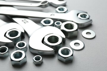 Metal wrenches and nuts on white background, closeup