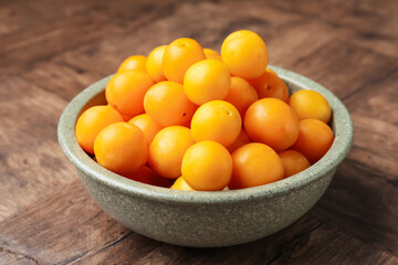 Ripe yellow cherry plums on wooden table, closeup