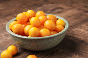 Ripe yellow cherry plums on wooden table, closeup