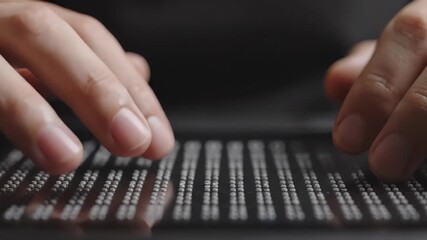 Fingers reading braille text on a digital accessibility device - Powered by Adobe