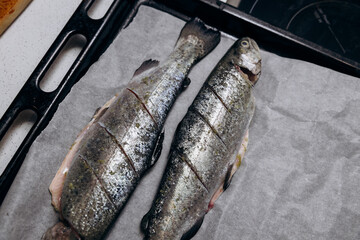 Raw trout lies on a cutting board for baking in the oven. Fish dinner recipes