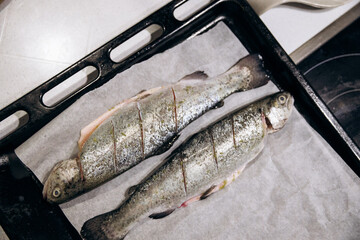 Raw trout lies on a cutting board for baking in the oven. Fish dinner recipes