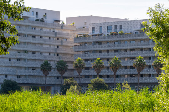 Large residential complex in Montpellier, France, with layered balconies and greenery, expressing modern architectural rhythm, community planning, and contemporary urban housing