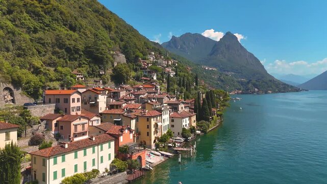 Lake Lugano, Valsolda, Italy. View of the lake, mountains and scenic village. A small Italian town by the lake in Albogasio Oria. Aerial 4K drone video footage