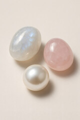 Collection of stones including rose quartz, moonstone and pearl, shot in studio setting. Gemstones for personal spiritual practice.