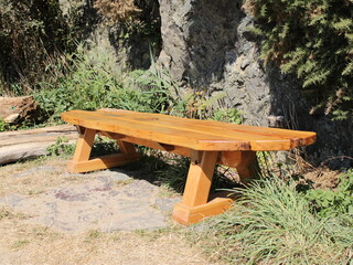 Wooden bench next to rock background
