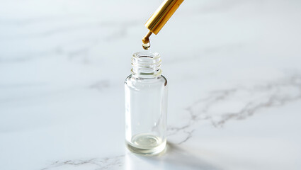 A golden dropper releases a drop of golden liquid into a clear glass bottle on a marble surface, highlighting a moment of precise cosmetic or medicinal application