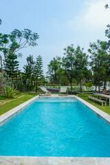 Empty swimming pool with sunbed and white umbrella in resort hotel for vacation leisure and white sand,resort neary sea and beach in summer.