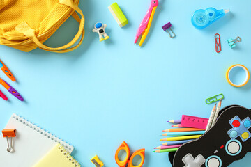 Colorful school supplies on blue background with copy space. Back to school concept.