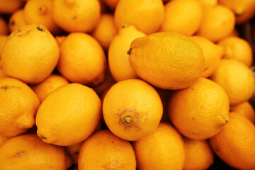 Fresh ripe yellow lemons piled at the market. Organic citrus fruit full of vitamin C, perfect for juice and cooking
