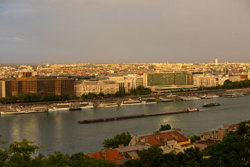 Fototapeta premium the Danube River in Budapest with rainbow at sunset, boats and a barge