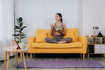 Woman Eating Salad on Sofa After Yoga
